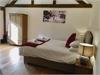 Beautiful Master Bedroom with vaulted ceiling and beams, window looking out onto the private garden/ courtyard.