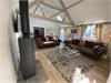 Stunning lounge area with vaulted ceiling and exposed beams. Modern wood burner.  Window to front elevation with stunning views across field.  Window to rear private garden and door out to rear private garden.