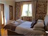 Master Bedroom with Kingsize bed.  Vaulted ceiling with beams. Original exposed Brick & Flint wall.  Window looking out across the countryside.