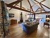 Stunning cosy lounge area with vaulted ceiling, exposed beams and exposed brick & flint walls, central woodburner for those cosy days/nights in.  Window over looking the meadow.